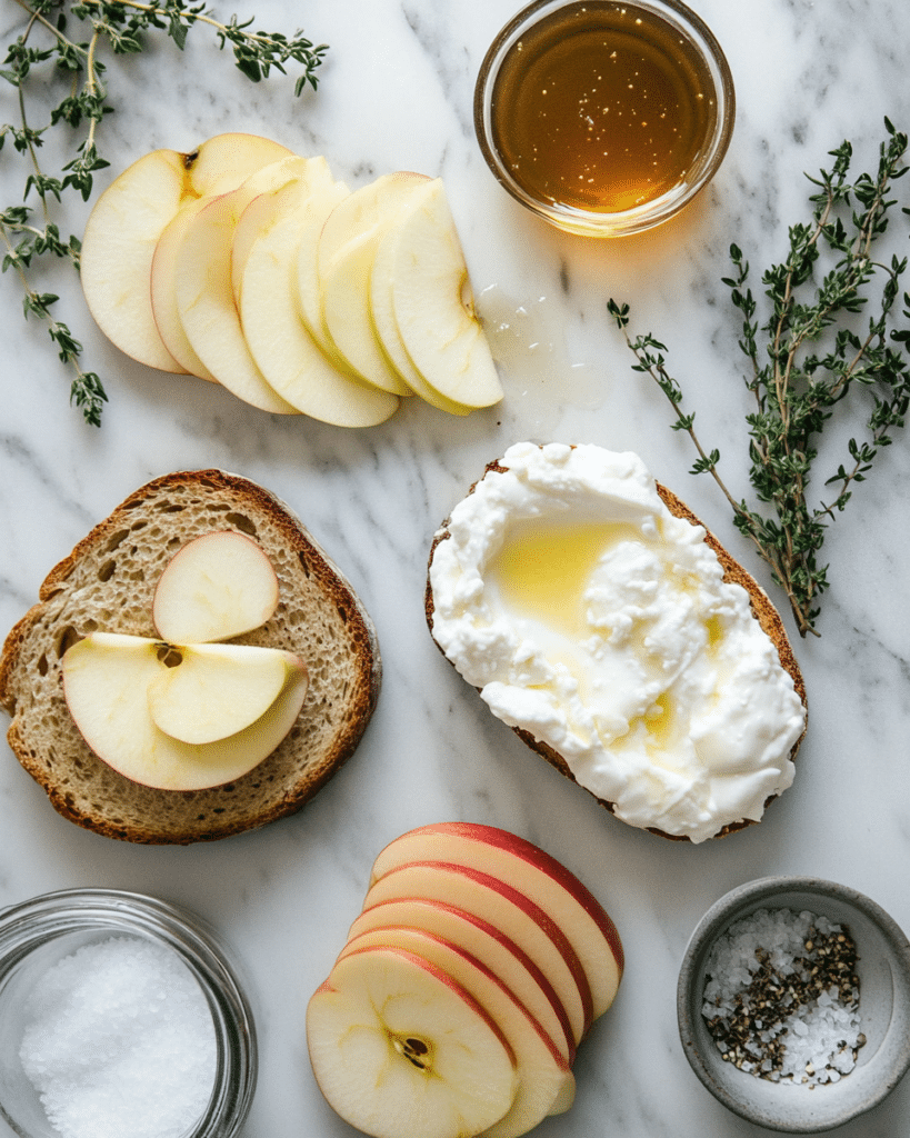 Ingredients for Apple and Honey Burrata Toast, including sourdough bread, burrata, apple, and honey.