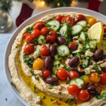 Greek Style Loaded Hummus served with pita bread and lemon wedges.