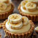Ingredients for No-Bake Mini Banana Cream Pies, including graham crackers, banana pudding, cream cheese, bananas, and cream.