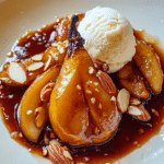 A close-up of Roasted Pears with Salty Caramel Sauce served with a scoop of vanilla ice cream.