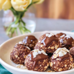Someone holding or eating one of the No-Bake Oat Chocolate Balls.
