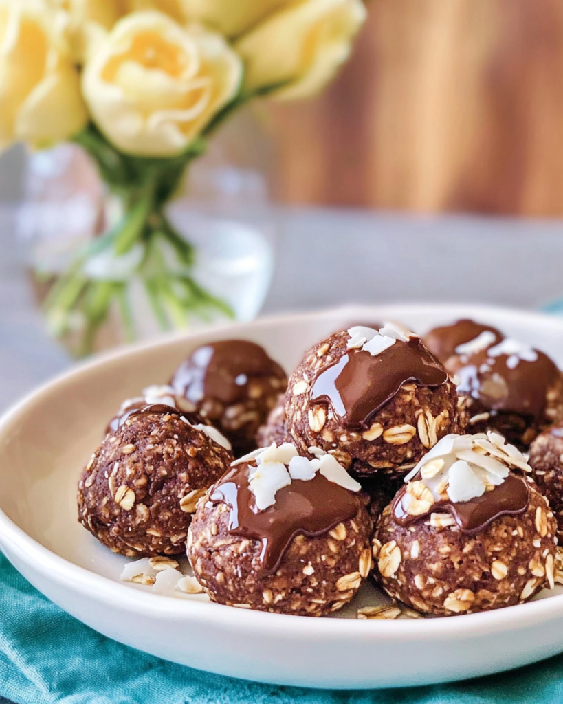 Someone holding or eating one of the No-Bake Oat Chocolate Balls.