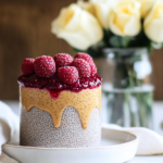 Layering the peanut butter mixture over the set chia pudding in a glass for Peanut Butter & Jam Chia Pudding.