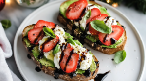 Beautiful slices of Strawberry Avocado Toast topped with creamy burrata, fresh strawberries, basil, and balsamic glaze.