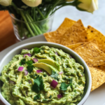 Mashing avocados and mixing with herbs and other ingredients in a bowl for Green Goddess Guacamole.