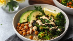 A vibrant Crispy Quinoa Chickpea Bowl showing crispy quinoa, roasted broccoli, roasted chickpeas, avocado slices, and tahini dressing.