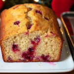 The whole Raspberry Lemon Bread loaf on a cutting board, partially sliced.