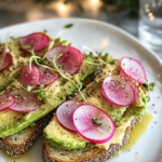 Ingredients for Cashew Cheese Avocado Toast, including avocados, cashews, nutritional yeast, lemon, watermelon radish, microgreens, and bread.