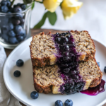 Spreading the blueberry chia jam layer over the batter in the loaf pan for Oatmeal Banana Bread.