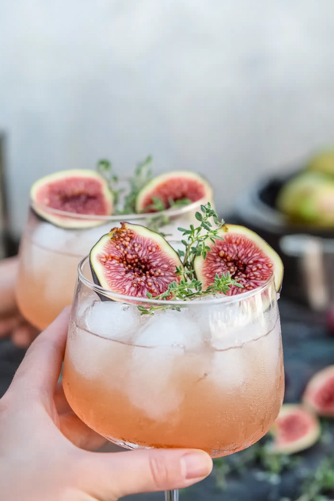 Pouring the shaken cocktail mixture over ice before topping with club soda for the Fig Thyme Shrub Cocktail.