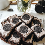 A close-up of a Cookies and Cream Brownie square, showing the fudgy base and creamy, cookie-studded frosting.