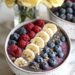 Pouring the thick purple acai smoothie next to the set chia pudding in a bowl for Acai Chia Pudding Bowls.