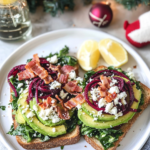 Assembling the Loaded Avocado Toast by layering roasted beets and swiss chard over avocado mash.