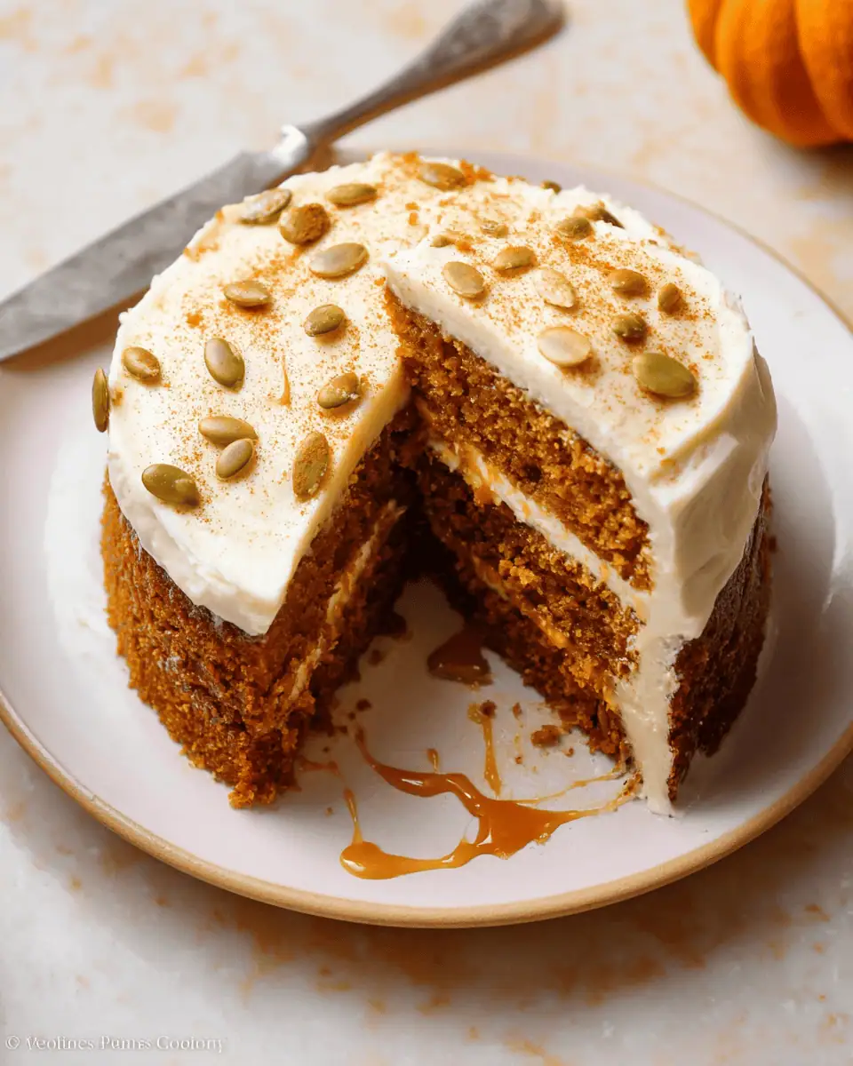 Ultimate Brown Butter Pumpkin Cake (with Dulce de Leche!) 1 A fork taking a bite of the moist pumpkin cake, highlighting the creamy frosting and rich filling.
