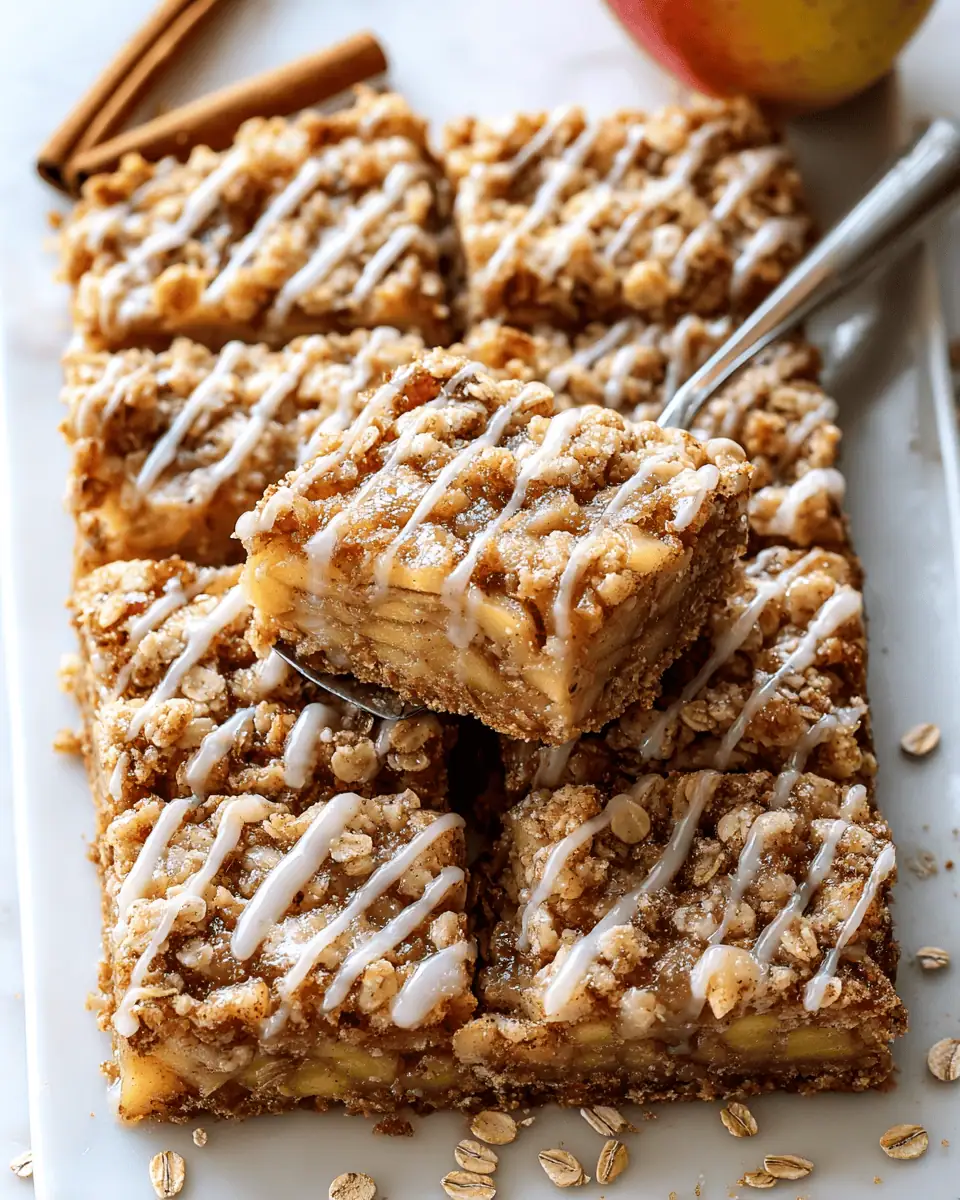 The Best Apple Crumble Bars (Easy 2-in-1 Crust!) 3 A 9x13 pan of golden-brown apple crumble bars, sliced into squares and drizzled with a white glaze.