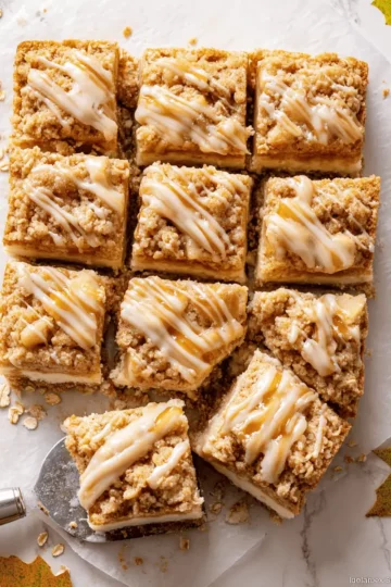 A stack of three apple cheesecake bars, highlighting the creamy cheesecake and tender apple layers.