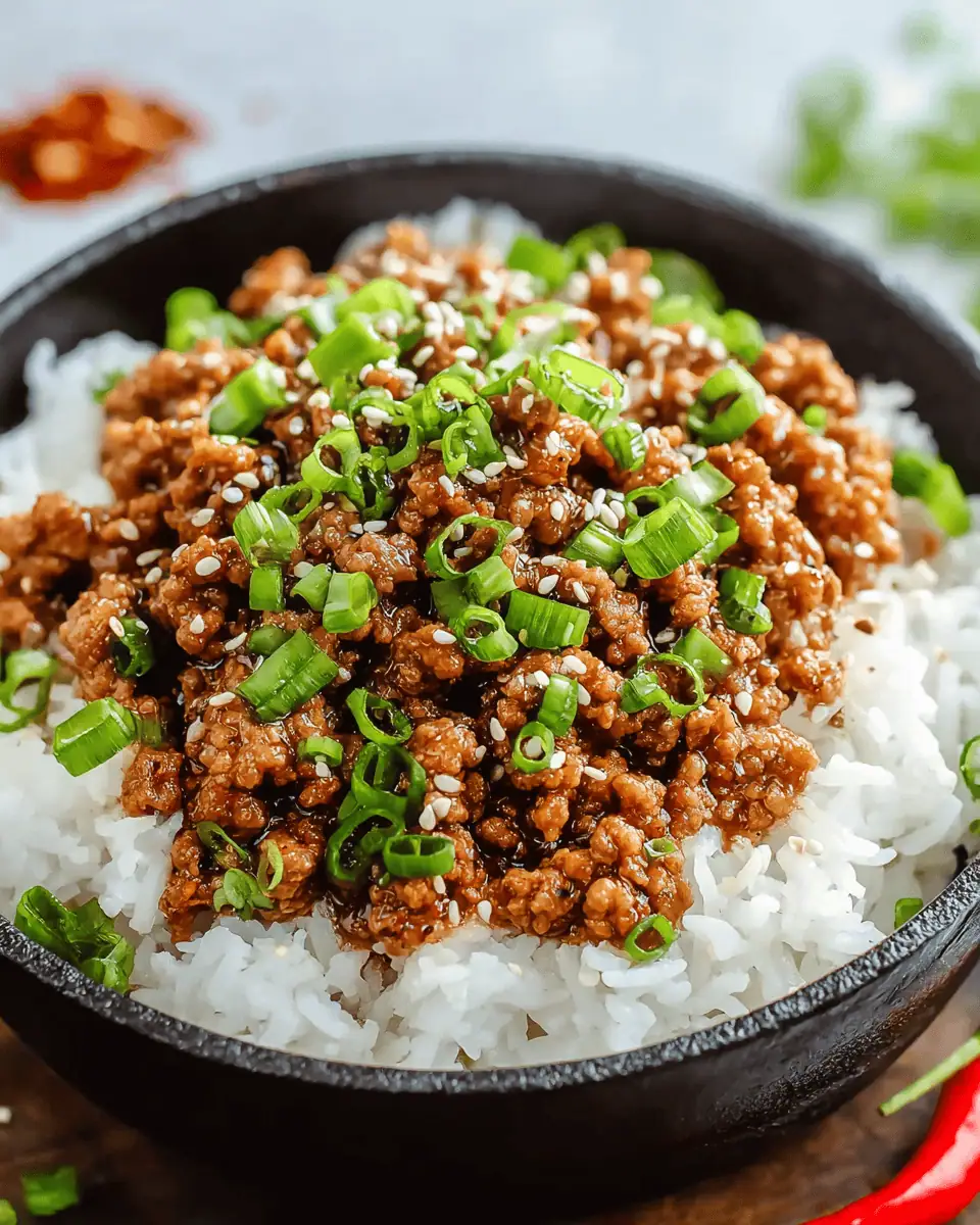A hand holding a crisp lettuce wrap filled with honey garlic ground turkey and topped with carrots.