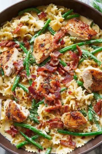 Creamy Chicken Pasta with Green Beans and Bacon: 30-Minute Dinner 8 A colander filled with cooked pasta and bright green beans being rinsed under cold water.