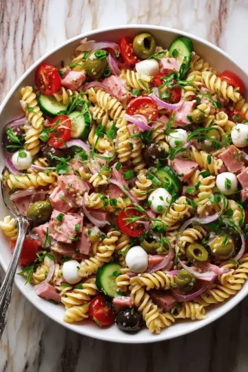 Italian Ham Pasta Salad with Mozzarella and Olives 6 A large bowl filled with fusilli pasta, cubed ham, mozzarella pearls, and fresh vegetables tossed in vinaigrette