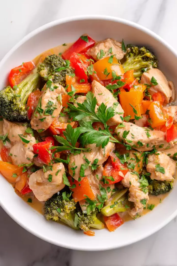 Healthy chicken stir-fry with fresh vegetables and a creamy sauce served in a bowl, showcasing a vibrant and colorful meal.