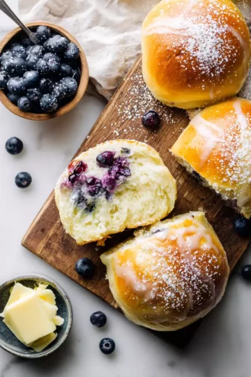 Soft and Fluffy Blueberry Brioche Buns 10 Blueberry brioche buns fresh out of the oven, soft and fluffy, perfect for breakfast or a snack, featuring plump blueberries and a golden-brown crust.