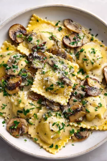 Mushroom Ravioli with Creamy Mushroom Sauce 5 Delicious mushroom ravioli served with rich cream sauce and garnished with parsley, a perfect vegetarian dish for any occasion.